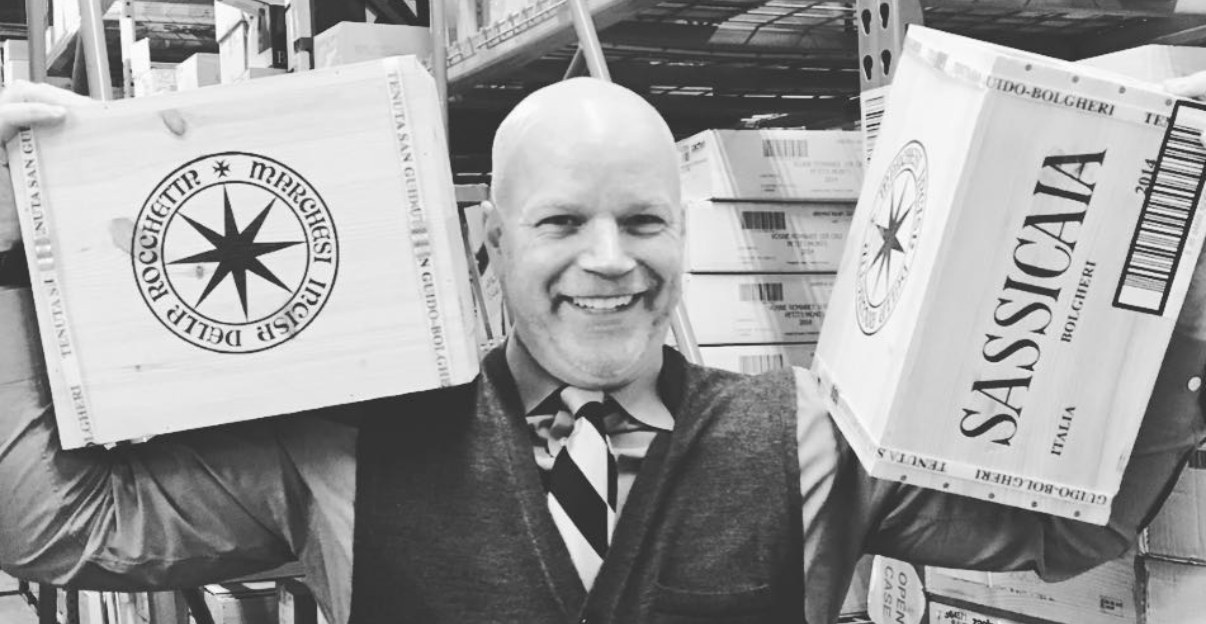 Andrew McMurray holding cases of Sassicaia and Tenuta San Guido
